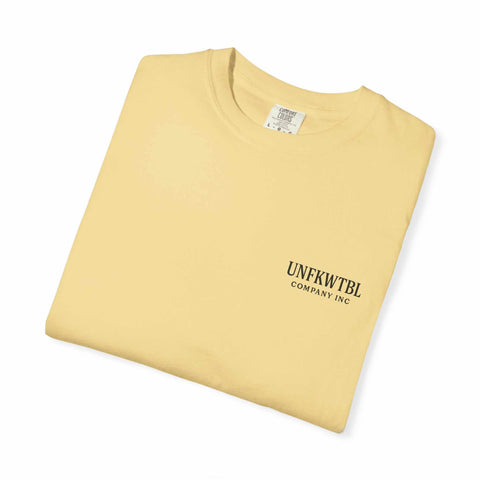 Folded beige Chucky Cocktail unisex T-shirt with UNFKWTBL Company Inc logo printed on the front.