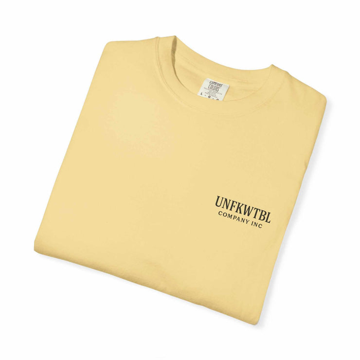 Folded beige Chucky Cocktail unisex T-shirt with UNFKWTBL Company Inc logo printed on the front.