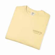 Folded beige Medusa Beauty unisex T-shirt with UNFKWTBL Company Inc logo.