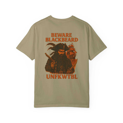 Blackbeard the Pirate graphic on khaki garment-dyed T-shirt with bold warning text and pirate ship background