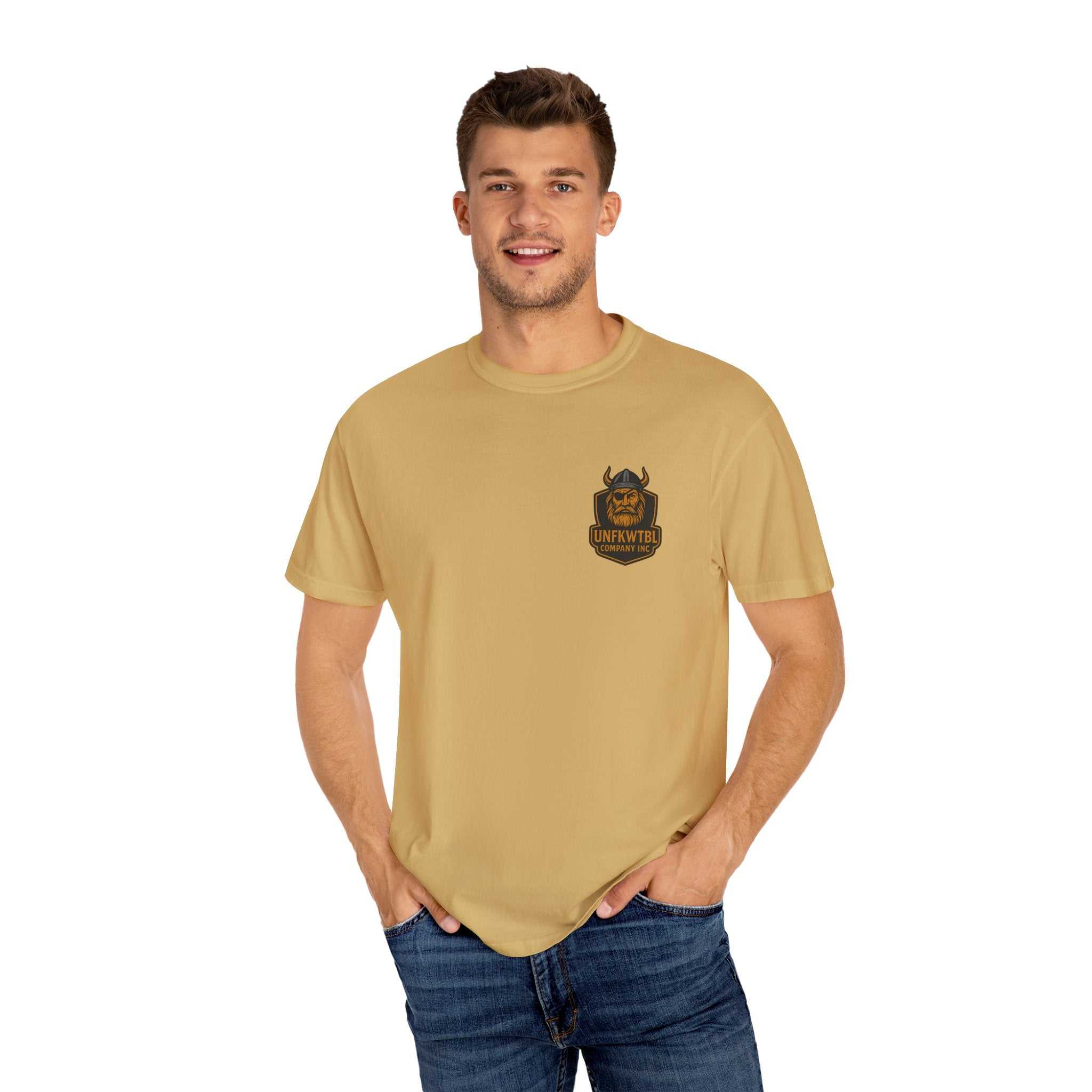 Man wearing a beige Tropical Humor T-Shirt with a small graphic logo on chest, casual summer unisex garment-dyed tee, styled with jeans.