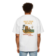 Men's Heavy Oversized Tee white with "Rule Your Peace" graphic on back worn by model from behind
