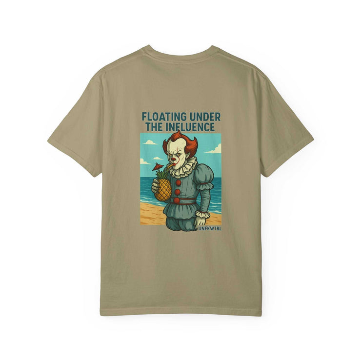 Unisex beige graphic t-shirt featuring Pennywise holding a pineapple with text "FLOATING UNDER THE INFLUENCE" on beach background