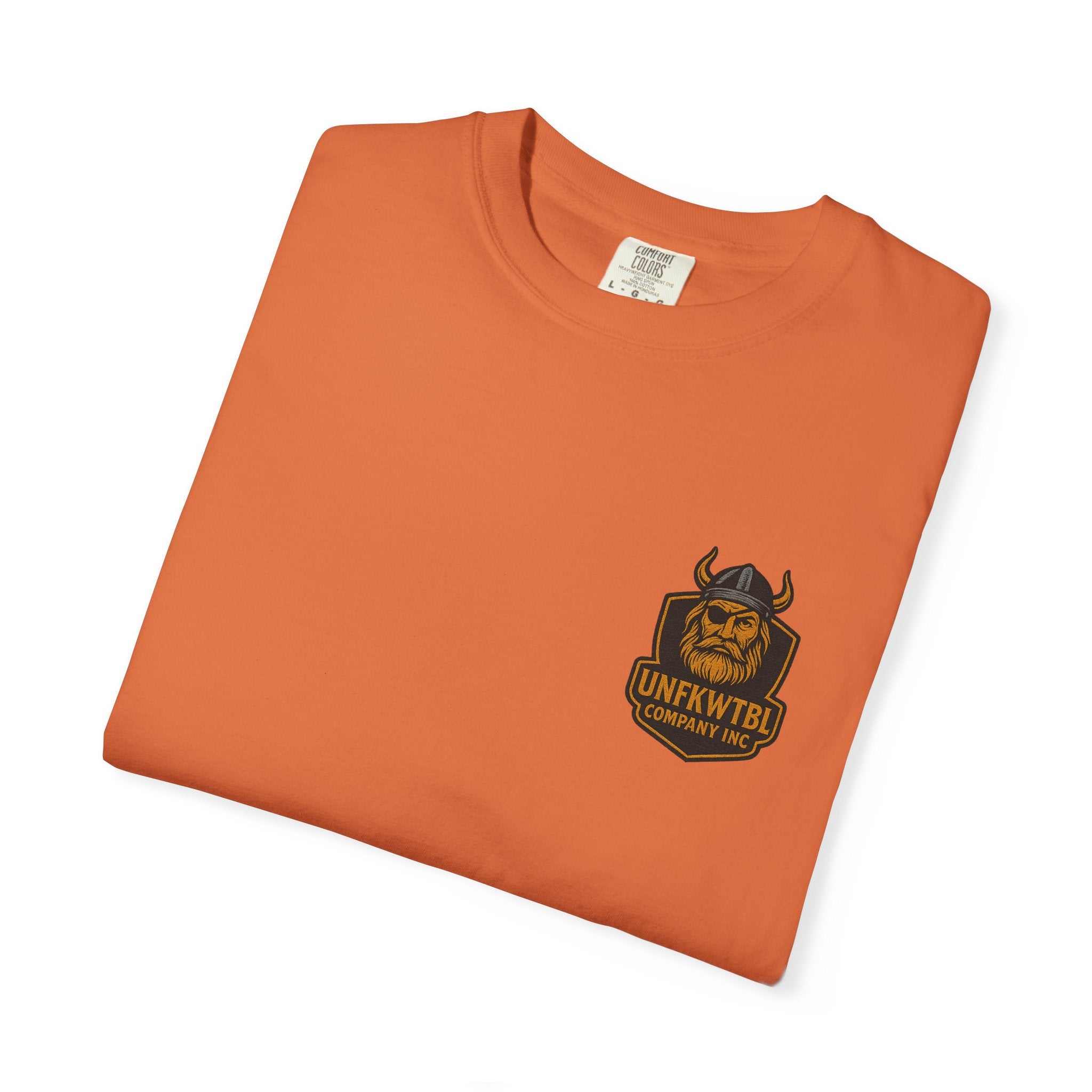 Folded orange unisex garment-dyed Tropical Humor T-Shirt with Viking logo on front pocket area, casual summer tee designed for beachwear and vacation.