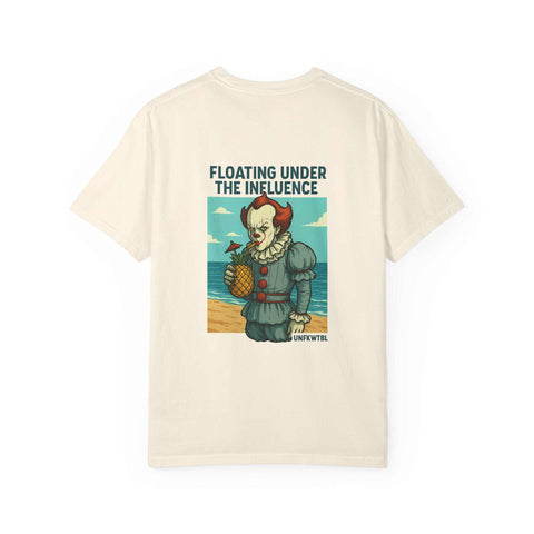 Unisex cream t-shirt with Pennywise clown graphic holding a pineapple and text "Floating Under The Influence" on beach background