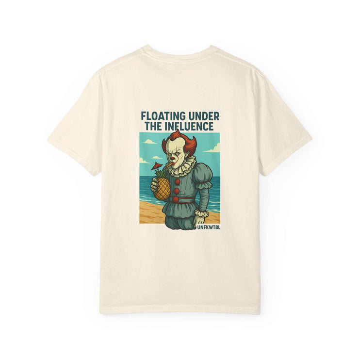 Unisex cream t-shirt with Pennywise clown graphic holding a pineapple and text "Floating Under The Influence" on beach background